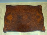 brown leather tray on a wooden floor with a white wall in the background
