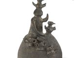 a bronze statue of a woman sitting on top of a rock