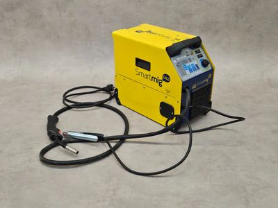 a close up of a yellow and black welding machine on a gray surface