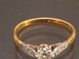 a gold ring with a diamond in it on a table