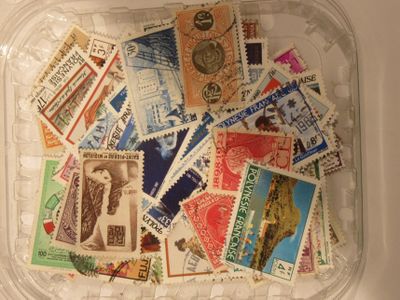 a plastic container filled with postage stamps on top of a table