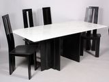 une table en marbre blanc avec des chaises noires et une chaise noire