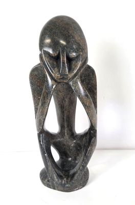 statue d'un homme dont la tête a la forme d'un hibou