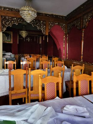de nombreuses tables et chaises dans un restaurant aux nappes blanches