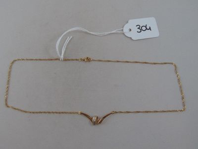a close up of a gold necklace on a white surface