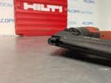 a close up of a stapler on a table with a red box in the background