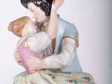 a figurine of a man and a woman sitting on a rock