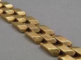une image d'un gros plan d'un bracelet en or sur une table