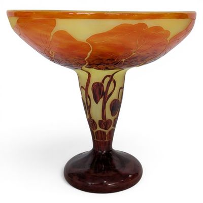 an orange and yellow glass bowl sitting on top of a wooden stand
