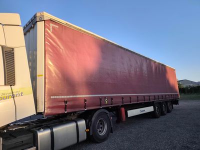 a red semi truck parked in a parking lot
