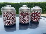 trois bocaux ornés de motifs rouges et blancs, posés sur le toit d'une voiture