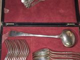 de nombreuses cuillères et fourchettes dans un coffret posé sur une table