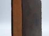 an old book that is sitting on a white surface