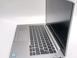 a silver laptop computer sitting on a white surface
