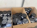 des boîtes remplies de peinture noire et blanche posées sur une table en bois