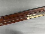 une vieille règle en bois surmontée d'une plaque en laiton