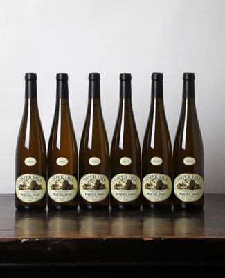 six bouteilles de vin sont alignées sur une table en bois