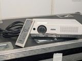 un projecteur posé sur un boîtier, avec une télécommande