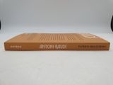 an orange book sitting on top of a white table next to a pair of shoes