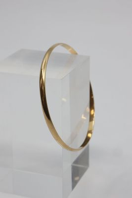 an image of a gold ring sitting on a clear block
