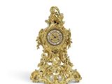 une horloge en or posée sur une surface blanche