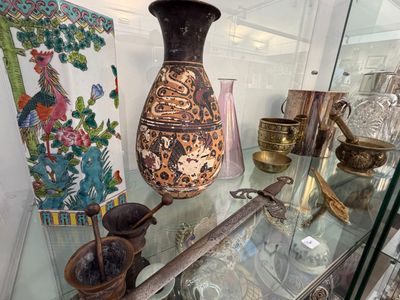 une vitrine en verre sur laquelle est posé un vase