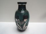 un vase bleu orné de fleurs noires et blanches