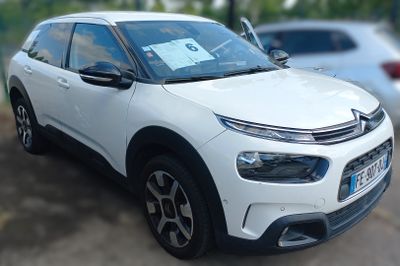 a white citrole parked in a lot next to other cars