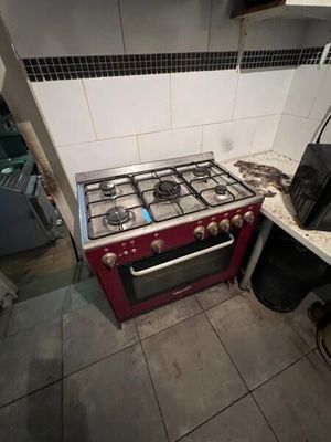 un four de cuisinière rouge installé dans une cuisine, à côté d'un évier