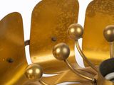a close up of a gold colored metal fan on a white surface