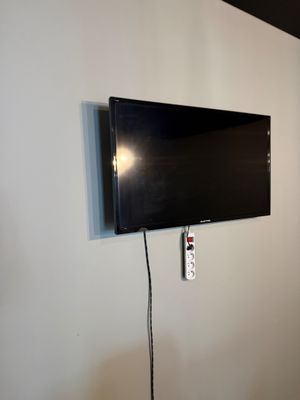 a flat screen tv mounted on the wall in the corner of a room
