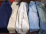 several pairs of men ' s jeans are stacked on top of each other