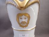 a white vase with a gold trim and a picture of jesus on it