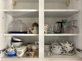 many dishes and cups on the shelves in the kitchen