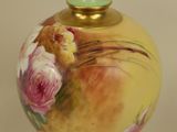 a green vase with a floral design on it