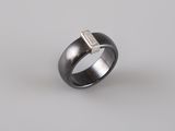 a black and white ring with a diamond in the middle