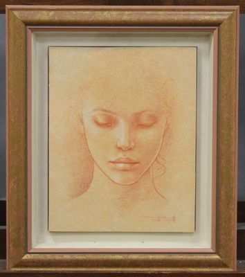 On voit le dessin du visage d'une femme dans un cadre doré