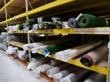 many rolls of fabric on the shelves in the store