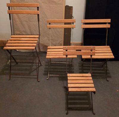 quatre chaises en bois et une table dans une pièce avec un mur
