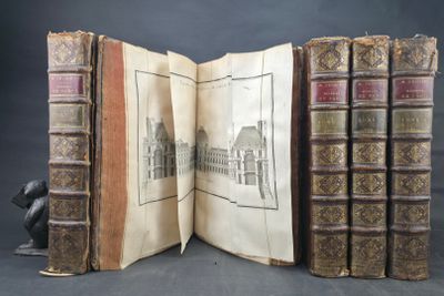three old books that are open on a table