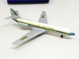 a toy airplane sitting on a table next to a pen