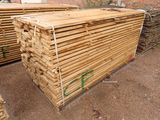a pile of lumber sitting on the ground in front of a building