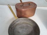 des casseroles et des poêles sont posées sur une table dans une pièce