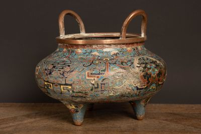 un petit vase muni d'une anse, posé sur une table en bois