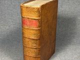 un vieux livre posé sur une table à côté d'un fond gris
