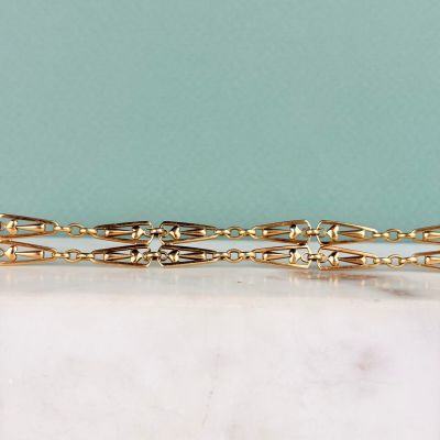 two gold tone hair clips on a marble counter top