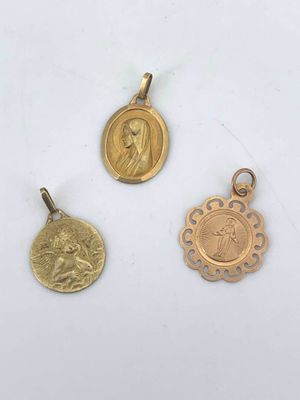 three gold pendants with a picture of a woman and a man