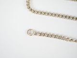 a silver chain that is laying on a white surface