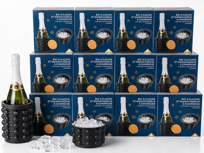 six bouteilles de champagne et des seaux à glace devant une pile de cartons