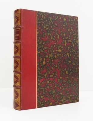 un vieux livre à la couverture rouge posé sur une surface blanche